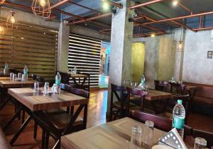 a restaurant with wooden tables and chairs and water bottles at Hotel National Tourist Home in Trichūr