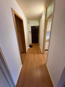 ein Flur einer Wohnung mit einer Tür und Holzböden in der Unterkunft Apartament 3 camere in Tîrnăveni