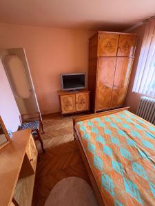 ein Schlafzimmer mit einem Bett und einem Fernseher in der Unterkunft Apartament 3 camere in Tîrnăveni