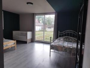 a bedroom with a bed and a large window at Parfaite pour toutes direction in Fenain