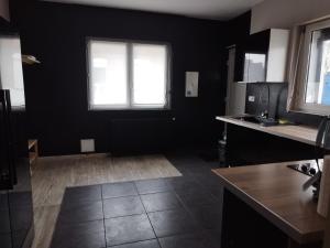 a kitchen with black walls and a window at Parfaite pour toutes direction in Fenain
