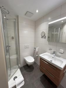 a bathroom with a toilet and a sink and a shower at Hotel Restaurant Sättele in Steißlingen +23 photos