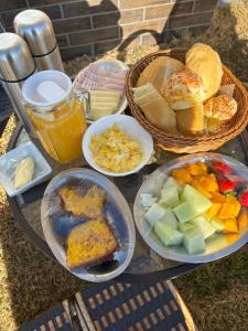 a table with various plates of food on it at Chalé com café da manhã Rancho Serrapilheira in Munhoz