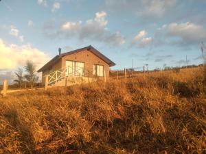 a house on a hill in a field at Chalé com café da manhã Rancho Serrapilheira in Munhoz