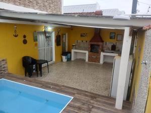 Casa com piscina praia grande Beach House في برايا جراندي: غرفة معيشة مع مسبح ومطبخ