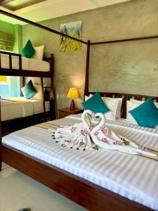 a bedroom with two beds with swans on them at Lanta Just Come Resort in Ko Lanta Yai +27 photos