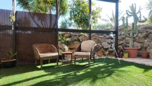 two chairs sitting on the grass in a garden at Countryside home Villa Luna with Private Yard & Jacuzzi in Alora