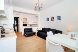 un soggiorno con un divano nero e una cucina di Pefka House Hanioti 6 guests 2 bedrooms a Hanioti