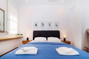 una camera da letto con un letto blu con due asciugamani bianchi di Pefka House Hanioti 6 guests 2 bedrooms a Hanioti