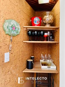 a wall with shelves with wine glasses and a clock at Vista Top - Casa prox centro 3Qts c/ churrasqueira in Poços de Caldas +36 photos