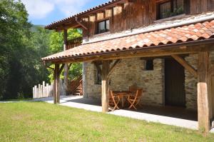 une maison en pierre avec une table en face dans l'établissement Arantza Apartamentuak, à Arantza