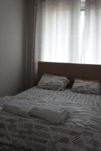 1 cama no hecha en un dormitorio con ventana en Stan u centru Niša, Obilićev venac, en Niš