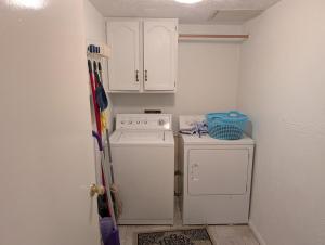 a small kitchen with a stove and a washer at Cozy Townhome in Missouri City +4 photos