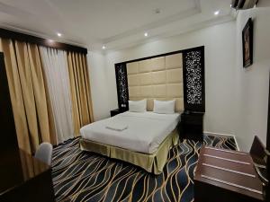 a hotel room with a bed and a bench at المهاجر للشقق المخدومة فرع قريش in Jeddah +49 photos