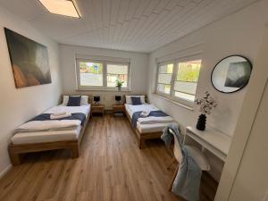 a room with two beds and two windows at Großzügige Ferienwohnung in Fleischwangen - Platz bis zu 8 Personen in Fleischwangen