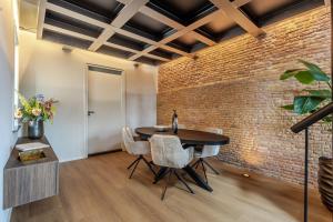 a dining room with a brick wall and a table and chairs at Exclusieve luxe B&B Het Renteniershuis in Molenaarsgraaf +15 photos