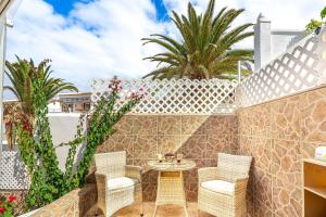a patio with wicker chairs and a table at Holiday Valley Harmony Bungalow in Adeje