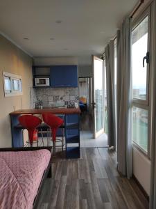 eine Küche mit blauen Schränken und einem Tisch mit roten Stühlen in der Unterkunft Container Cubo Hotel in Quequén
