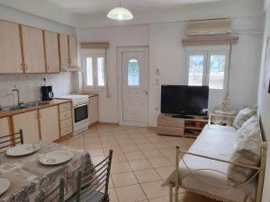 a kitchen with a table and a tv in a room at Plateia House in Zekros +3 photos