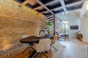 a brick wall in a dining room with a table and chairs at Exclusieve luxe B&B Het Renteniershuis in Molenaarsgraaf