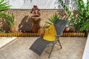 a chair sitting on a patio with plants at Holiday Valley Harmony Bungalow in Adeje