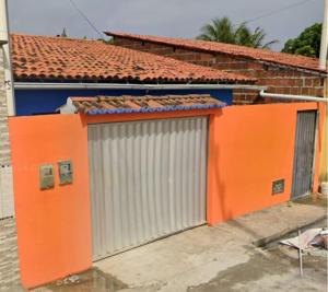 バイーア・フォルモーザにあるCasa Fundo de Quintalの正面に2つのガレージドアがあるオレンジ色の建物