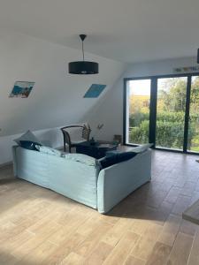 a living room with a couch and a table at Rose et violette in Brélès