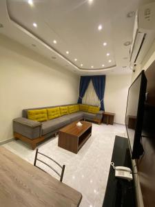 a living room with a couch and a table at شقق برج ملاذ للشقق المخدومة 