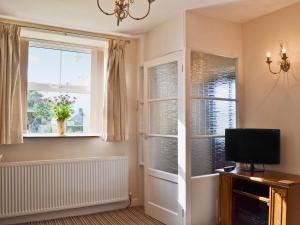 a living room with two windows and a television at Forest View in Peak Forest