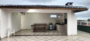 a patio with a table and a kitchen on a roof at Cobertura Duplex, PiSCiNA, Churrasqueira e Alegria in Guaratuba +5 photos