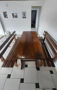 a wooden table in a room with two benches at Cobertura Duplex, PiSCiNA, Churrasqueira e Alegria in Guaratuba