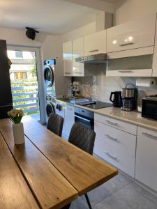 a kitchen with a wooden table and white cabinets at The Country Stop Apartment in Łęki