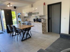 een keuken met een houten tafel en stoelen in een kamer bij The Country Stop Apartment in Łęki