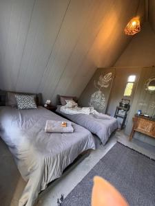 two beds in a room with a attic at White Linen Guesthouse in Tierpoort