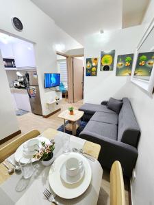 マニラにあるGalel's Comfort Zone 2BR Trees Residences Fairviewのソファとテーブルのあるリビングルーム