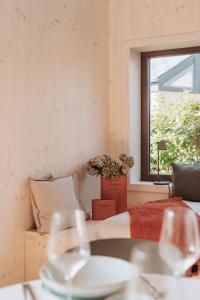 Habitación con mesa con sillas y ventana. en Die Tinys - Tiny Häuser am Attersee, en Nussdorf am Attersee