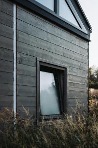 una gran ventana en el lateral de un edificio en Die Tinys - Tiny Häuser am Attersee, en Nussdorf am Attersee
