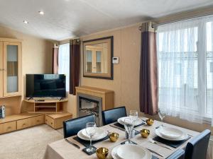 a dining room with a table and a television at Keswick Reach in Cockermouth