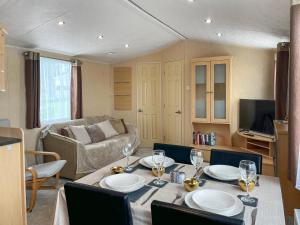 a living room with a table with plates and wine glasses at Keswick Reach in Cockermouth