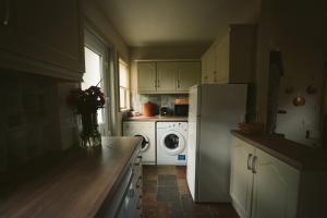 uma cozinha com uma geladeira branca e uma máquina de lavar em Longford Holiday Yellow Star Self-Catering Cottage em Esker South