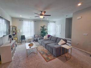 a living room with a couch and a ceiling fan at Impeccable 3BR Townhouse Near RDU & Hospitals in Cary