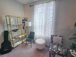 a living room with a chair and a window at Impeccable 3BR Townhouse Near RDU & Hospitals in Cary