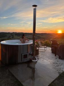a woman sitting in a bath tub with the sunset at Le Relais de D'Artagnan in Peyrusse-Grande