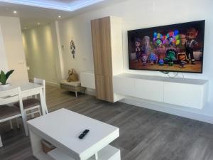 a living room with a flat screen tv on a wall at Sueña Mar Luxury Suites in Torrevieja