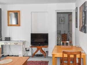 a living room with a television and a table at The Haven in Shanklin