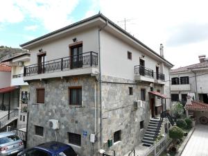 カストリアにあるLassani Apartmentsのバルコニー付きの大きな石造りの建物