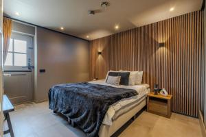 a bedroom with a bed and a wooden wall at Luxe B&B Het Rijgebint in Molenaarsgraaf