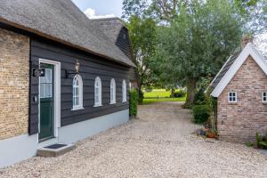 a house with a black and white exterior at Luxe B&B Het Rijgebint in Molenaarsgraaf