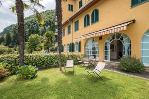 a house with chairs and a table in the yard at Terrace on the Lake in Oliveto Lario