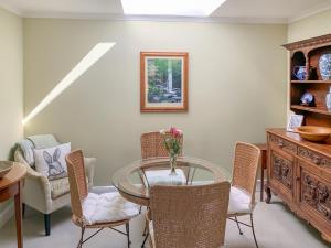 Un comedor con una mesa de cristal y sillas. en Capelrig, en Balfron